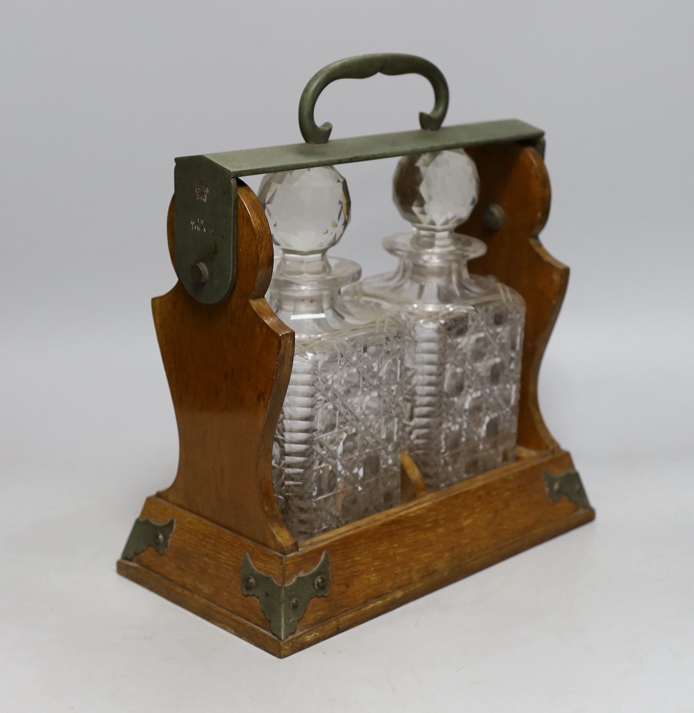 An Edwardian Betjemann’s Patent two bottle oak tantalus, 17cms wide